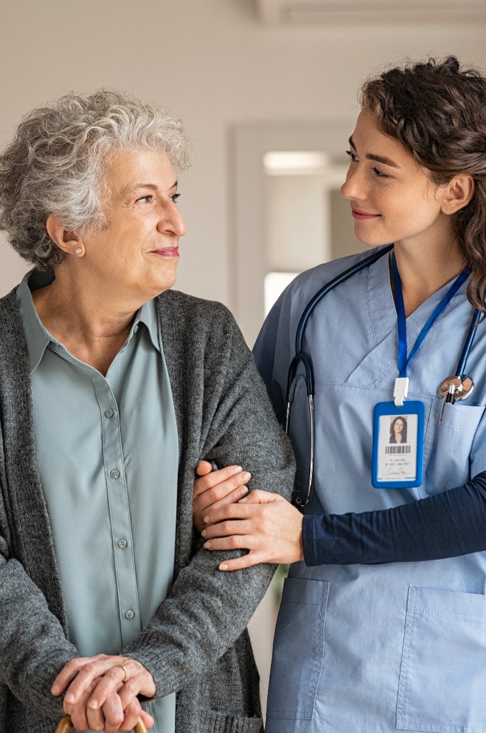 Betreuerin unterstützt ältere Frau zu Hause