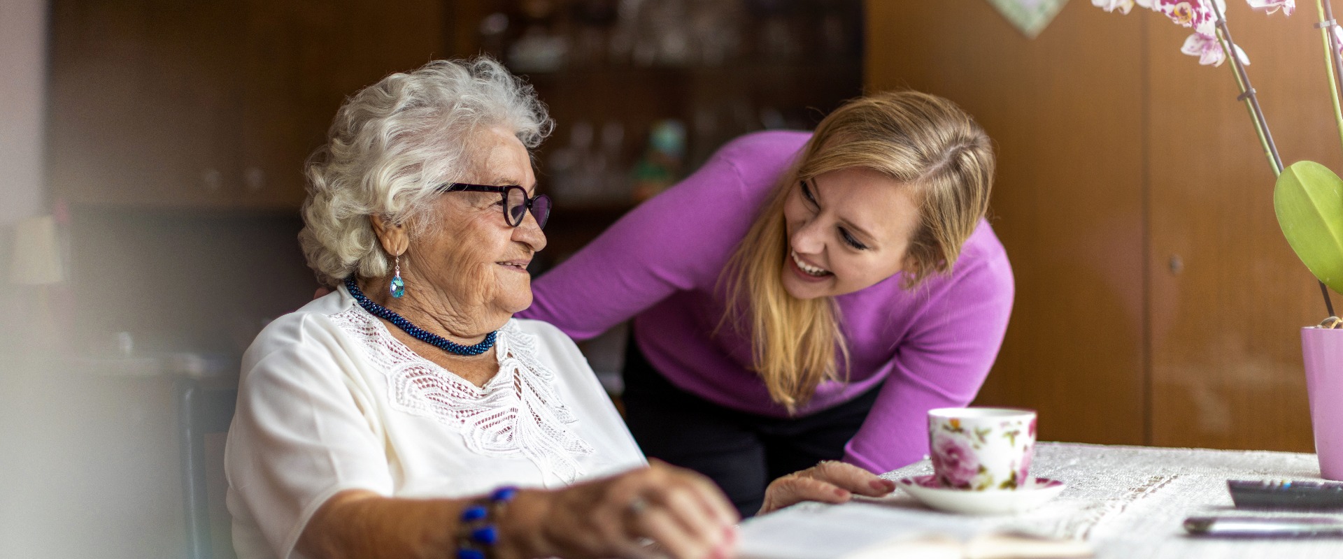 Young woman spending time with her elderly grandmother at home